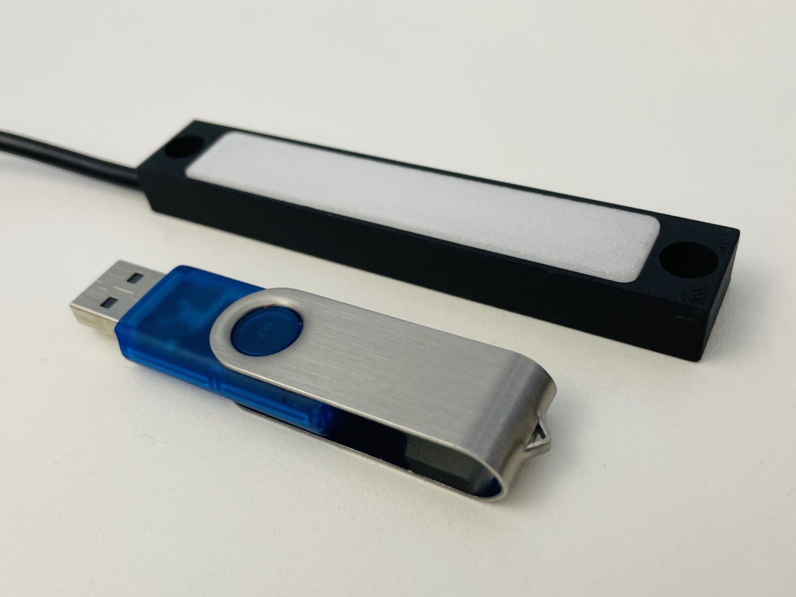 Kleine, flache elitra LED-Leuchte als Sonderanfertigung im Größenvergleich mit USB-Stick